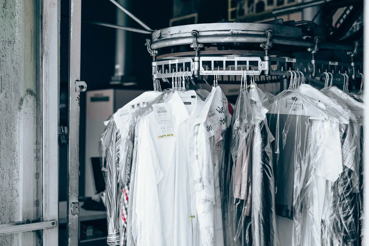 Cleaned shirts hanging in protective covers on a conveyor