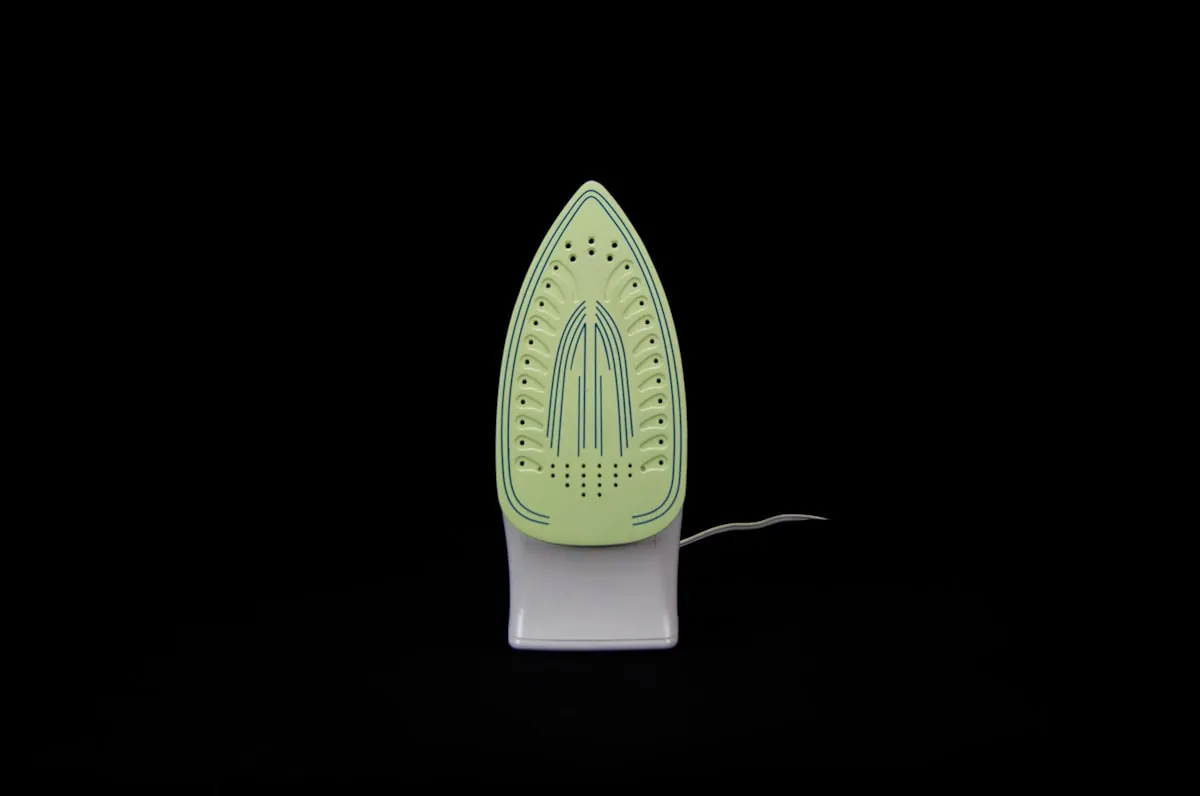 A steam iron photographed against a dark background